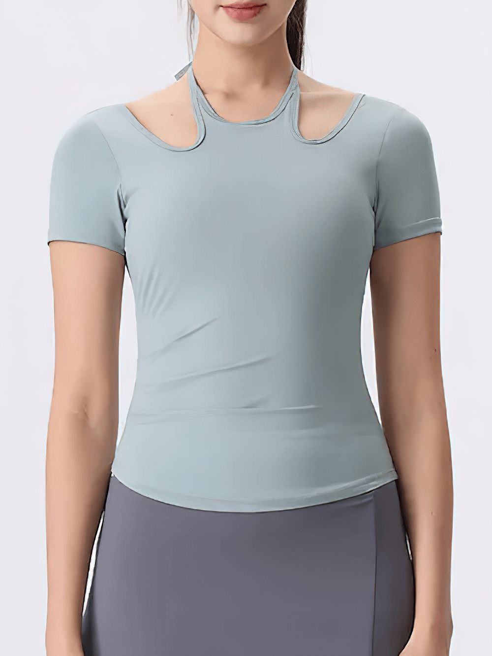 Woman wearing a sleek cross-back athletic yoga t-shirt with unique neckline, ideal for fitness and active lifestyle.